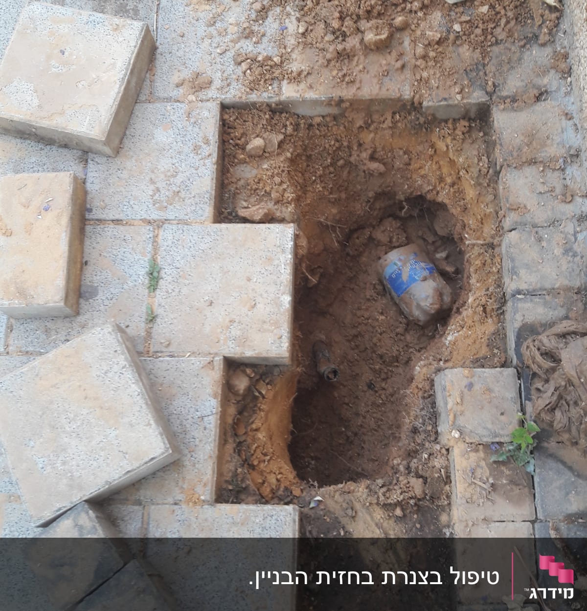 בור באדמה עם צינור חשוף ועבודות חפירה